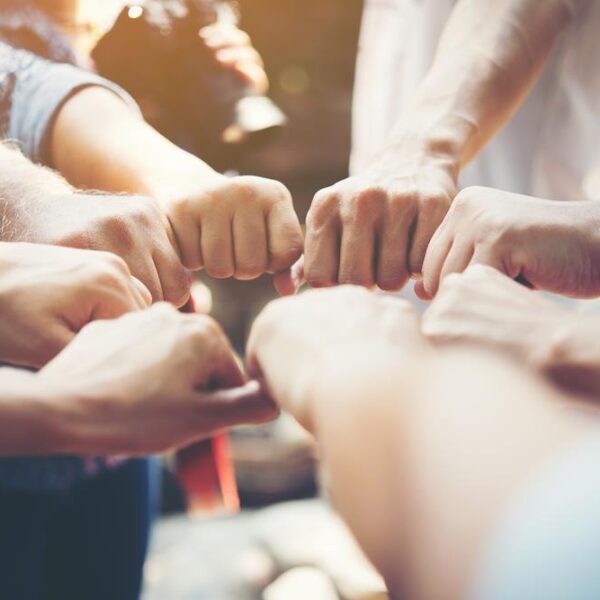 Close up of young people putting their hands together. Team with stack of hands showing unity and teamwork.